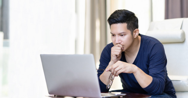 Man reading a fake Microsoft account notification.