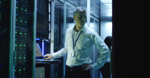 IT technicians work on laptops in a data center