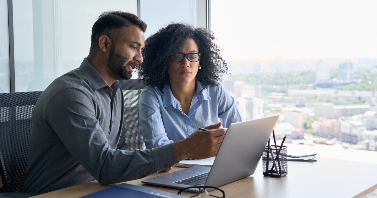 Multiethnic-colleagues-sitting-at-desk-l