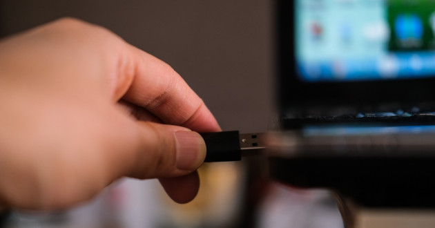 Plugging a USB cable into a port of a laptop