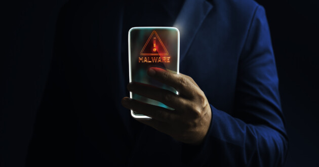 A person in a blue jacket holding a smartphone face out with red warning on screen