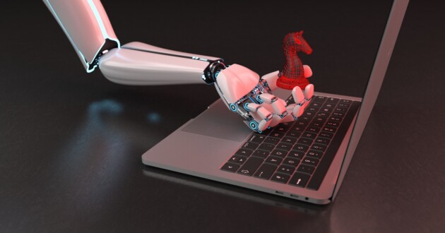 Robot hand with red trojan horse being held over a laptop on a desk