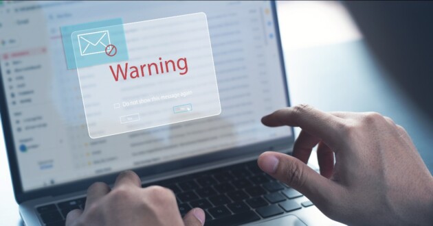 Closeup on a laptop displaying a warning for possible spam email