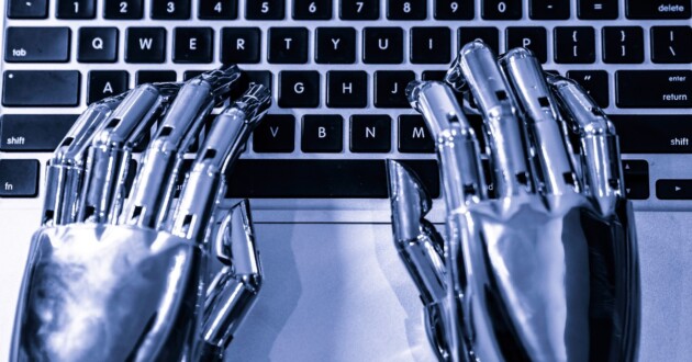 Closeup on a pair of silver metallic robot hands typing on a keyboard